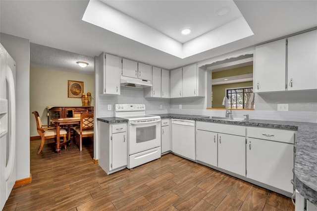 kitchen with white cabinetry, white appliances, sink, and hardwood / wood-style floors