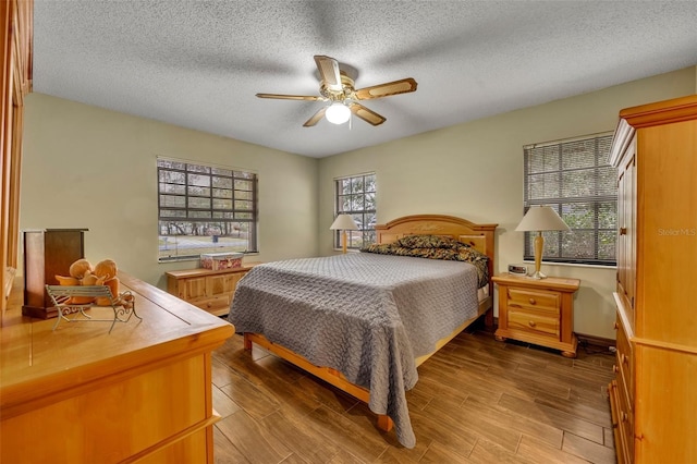 bedroom featuring ceiling fan, wood-type flooring, and a textured ceiling