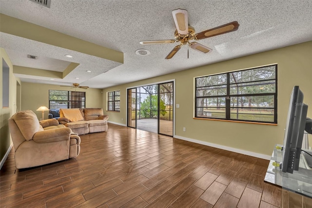 living room featuring a textured ceiling and ceiling fan