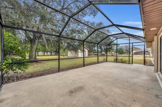 view of patio / terrace featuring glass enclosure and a storage shed