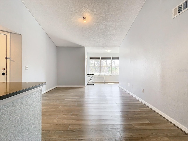 unfurnished living room with dark hardwood / wood-style floors and a textured ceiling