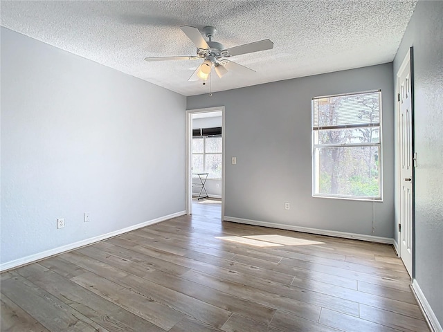 empty room featuring ceiling fan, a textured ceiling, and light hardwood / wood-style floors