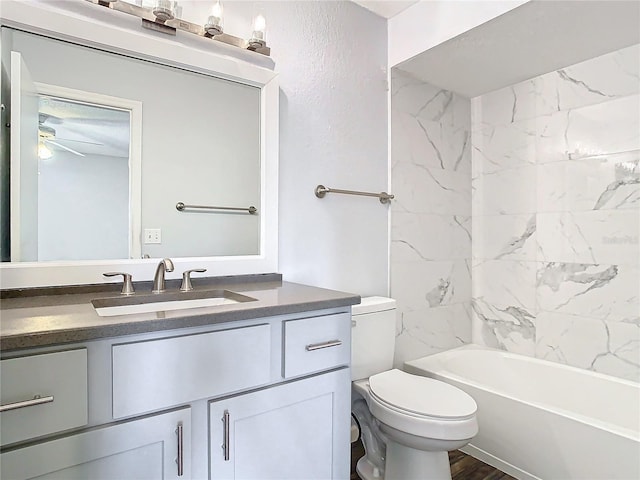 full bathroom with toilet, vanity, tiled shower / bath combo, hardwood / wood-style flooring, and ceiling fan