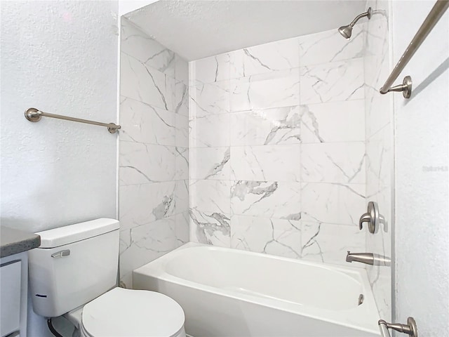 bathroom featuring tiled shower / bath combo and toilet