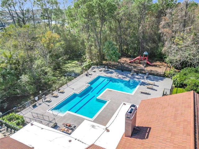 view of swimming pool with a playground and a patio