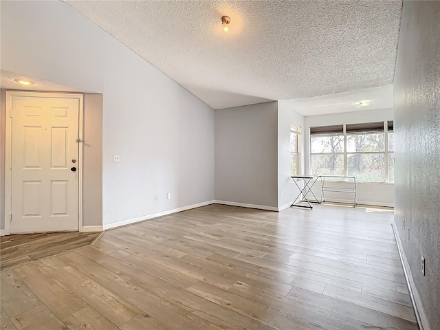 unfurnished living room with light hardwood / wood-style floors and a textured ceiling