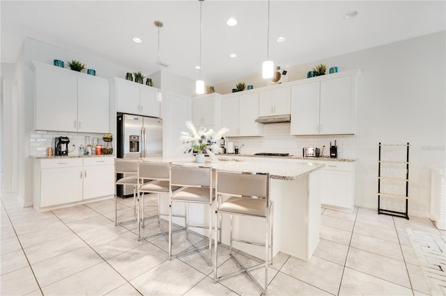 kitchen featuring a kitchen island with sink, white cabinets, and stainless steel refrigerator with ice dispenser