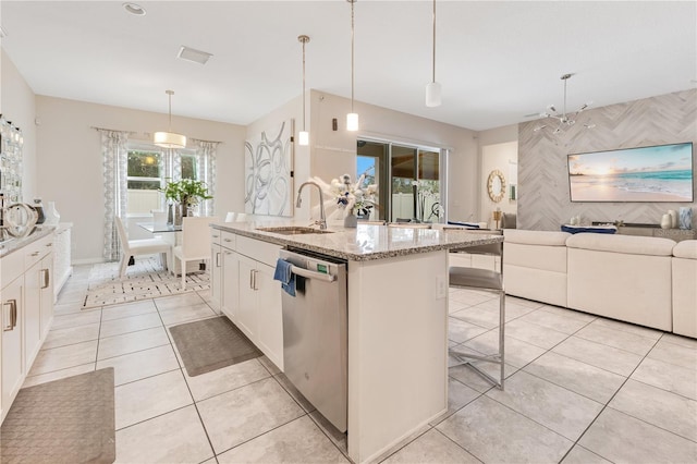 kitchen with a center island with sink, stainless steel dishwasher, white cabinets, and decorative light fixtures