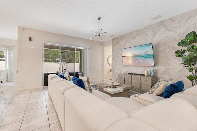 living room featuring an inviting chandelier, light tile patterned floors, and a textured ceiling