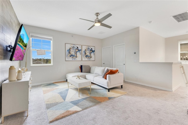 carpeted living room with ceiling fan