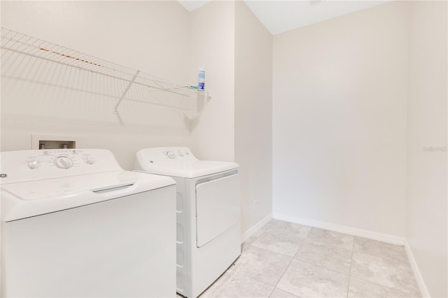 laundry area with light tile patterned floors and washing machine and clothes dryer