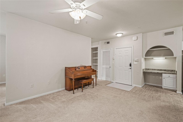 miscellaneous room featuring ceiling fan and light carpet