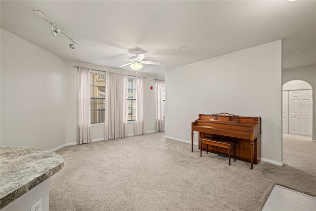 miscellaneous room featuring ceiling fan, track lighting, and carpet