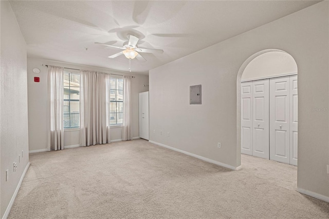 carpeted spare room featuring a textured ceiling, electric panel, and ceiling fan