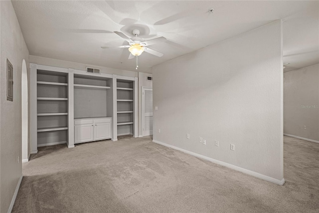 unfurnished bedroom with ceiling fan, light colored carpet, and electric panel