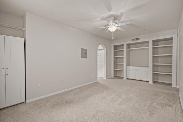 unfurnished bedroom with ceiling fan, light colored carpet, and electric panel