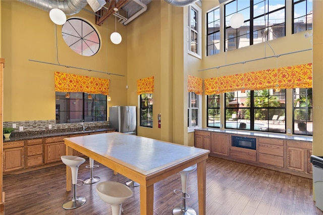 kitchen with sink, light brown cabinets, stainless steel fridge, and dark hardwood / wood-style flooring