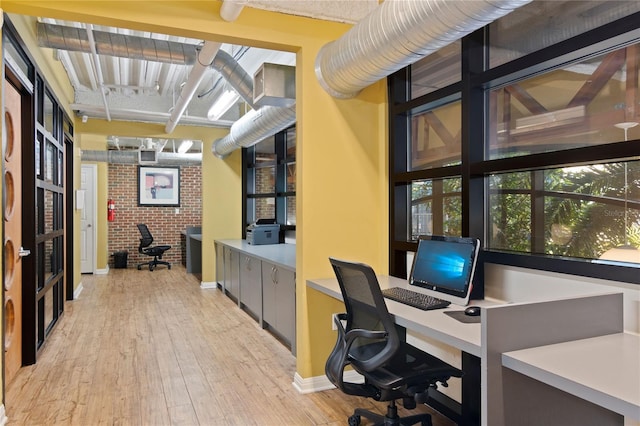 office area featuring brick wall and light wood-type flooring