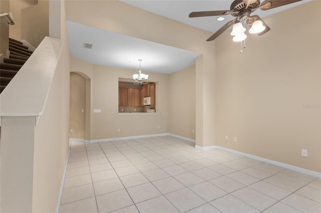980 Crestwood Commons Ave, Ocoee, FL 34761 - spare room with arched walkways, ceiling fan, a chandelier, light tile patterned floors, and baseboards