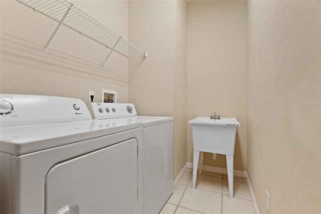 980 Crestwood Commons Ave, Ocoee, FL 34761 - laundry room featuring washing machine and clothes dryer, light tile patterned floors, and baseboards