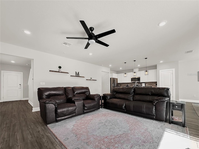 living room with wood-type flooring and ceiling fan