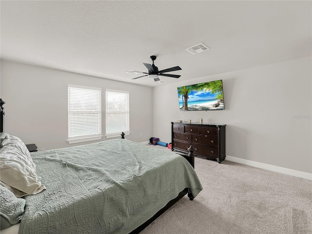 bedroom with light colored carpet, a textured ceiling, and ceiling fan