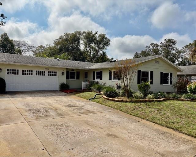 ranch-style home with a garage and a front lawn