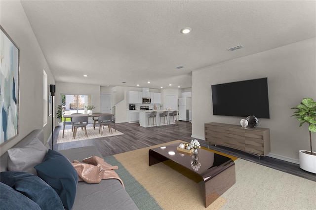 living room with dark hardwood / wood-style floors and a textured ceiling