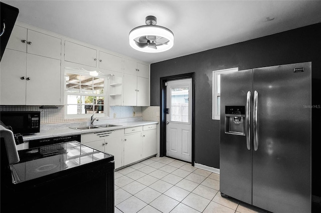 kitchen with sink, tasteful backsplash, black appliances, white cabinets, and light tile patterned flooring