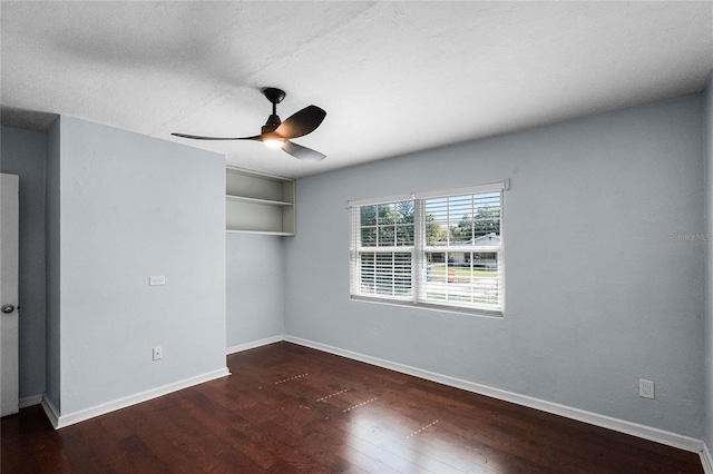 empty room with dark hardwood / wood-style floors, a textured ceiling, and ceiling fan