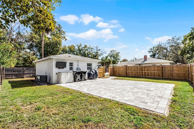 rear view of house featuring a yard, a patio, and central air condition unit