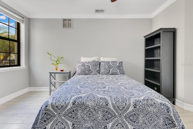 bedroom with crown molding and light hardwood / wood-style floors