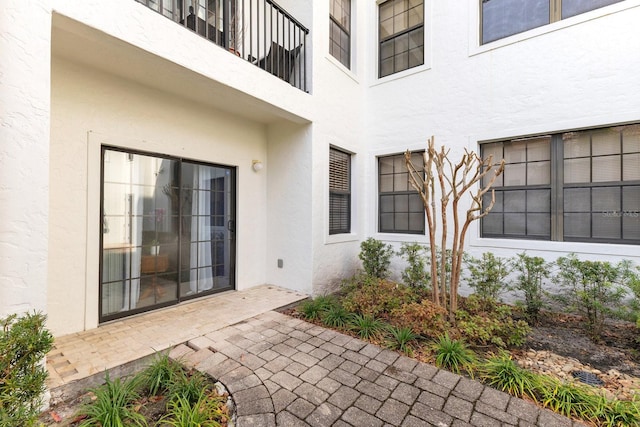 view of exterior entry with a patio area