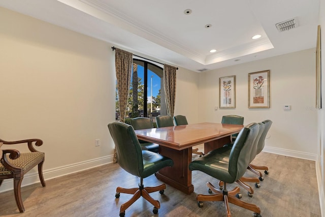 dining area featuring ornamental molding, hardwood / wood-style floors, and a tray ceiling