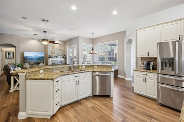 kitchen featuring pendant lighting, sink, white cabinetry, and appliances with stainless steel finishes