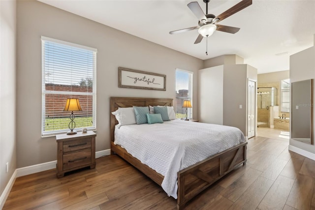 bedroom featuring ceiling fan, ensuite bathroom, and dark hardwood / wood-style floors