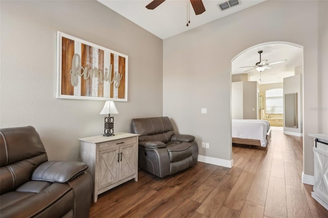 living area featuring dark wood-type flooring and ceiling fan