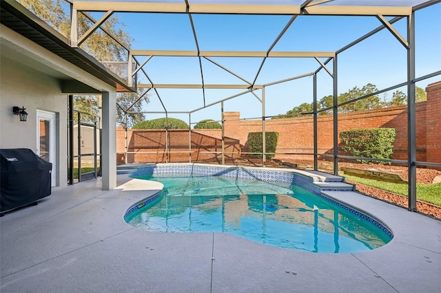 view of swimming pool featuring a patio, a grill, and glass enclosure