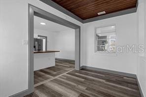 corridor featuring dark hardwood / wood-style flooring and wooden ceiling