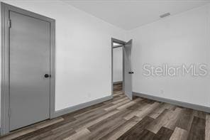 unfurnished bedroom featuring dark wood-type flooring