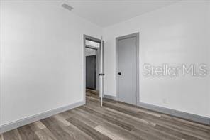 spare room with wood-type flooring