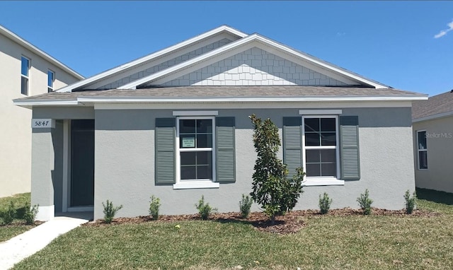 5879 Galloping Dr, Apopka, FL 32712 - view of front of property with a shingled roof, stucco siding, and a front lawn