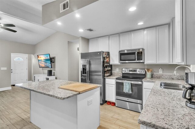 kitchen featuring appliances with stainless steel finishes, a center island, sink, and white cabinets