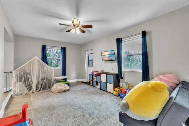 game room featuring hardwood / wood-style floors, a textured ceiling, and ceiling fan