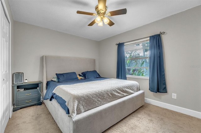 bedroom with light carpet, ceiling fan, and a closet