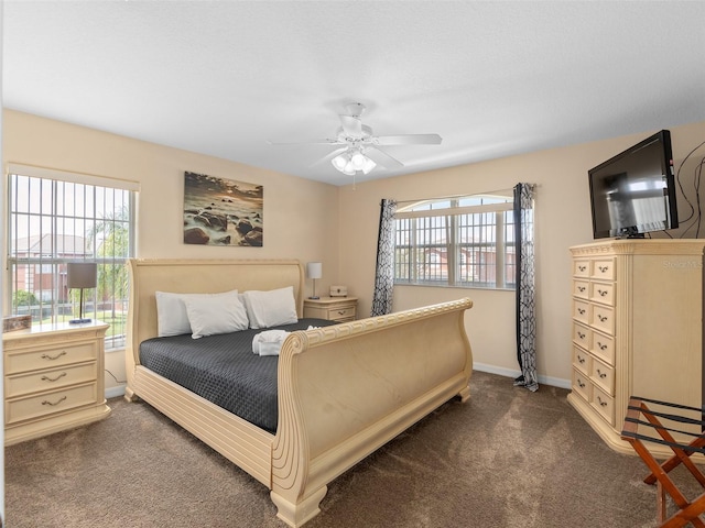 carpeted bedroom featuring multiple windows and ceiling fan