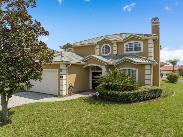 mediterranean / spanish house featuring a garage and a front lawn