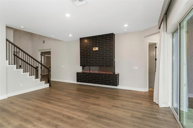 unfurnished living room with hardwood / wood-style flooring and a fireplace