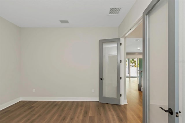 unfurnished room with dark wood-type flooring