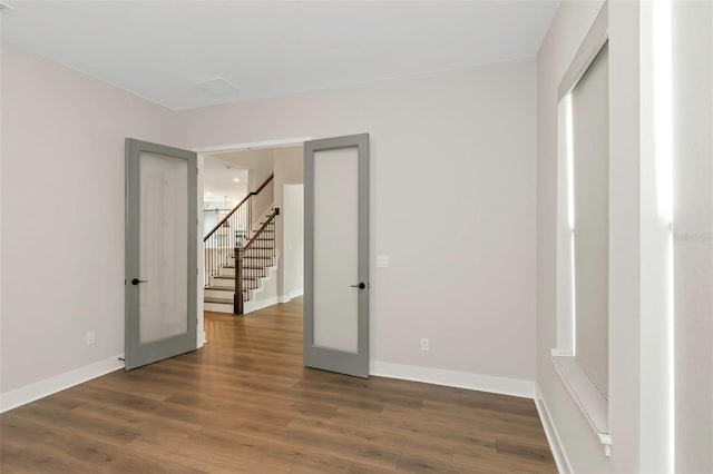 empty room featuring dark hardwood / wood-style flooring and french doors